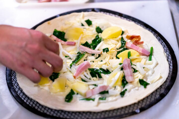 クリーム系ピッツァを厨房で作成中