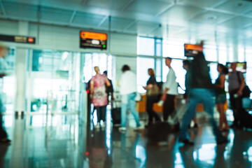 Defocused blur silhouettes of commuter in side international airport gate peoples carrying a small cabin luggage - boarding to the plane