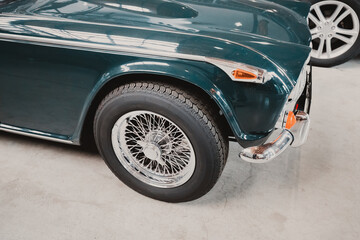A close-up of the details and wheels of a retro car on display at the automobile museum.