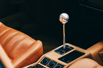 the gearshift lever in the interior of a luxury car with leather upholstery seats