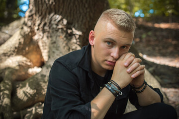 Young stylish Nordic blonde guy, portrait of modern youth. Confident boy with stylish clothes and accessories