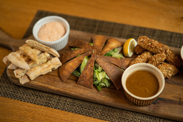 Close up image of served baba ghanoush meal on wooden board.