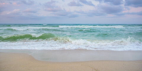 Fototapeta na wymiar velvet season seascape. waves rushing on the beach. cloudy sky before the evening storm