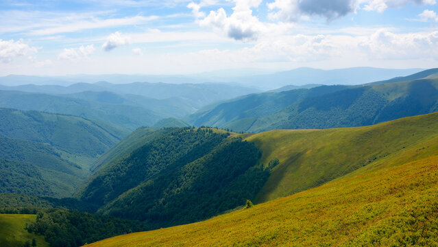 summer mountain scenery. view in to the distant rural valley. green meadows and forested hills. sunny weather. beautiful nature of carpathians