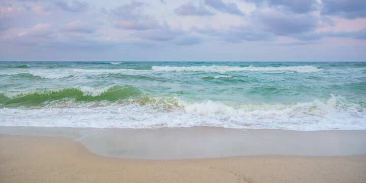 velvet season seascape. waves rushing on the beach. cloudy sky before the evening storm