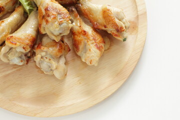 Barbecue chicken drumsticks on wooden plate with copy space