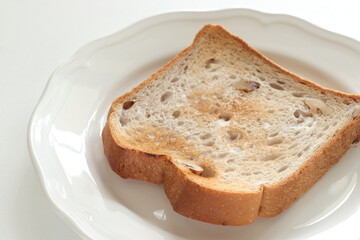 Toasted walnut bread on white dish with copy space