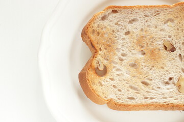 Toasted walnut bread on white dish with copy space