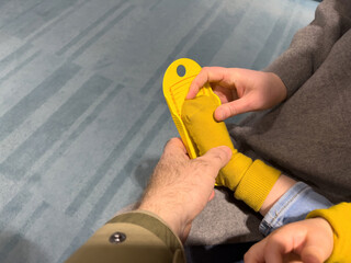 Seller measuring the kids feet with special measuring instrument made from plastic in order to know the right size fro the infants feet