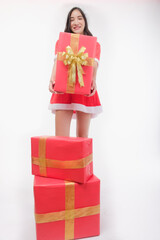 A dark-haired Asian woman in a red Santa Claus costume poses and looks at the camera, isolated on a white background. Add a message banner to sell items. shopping