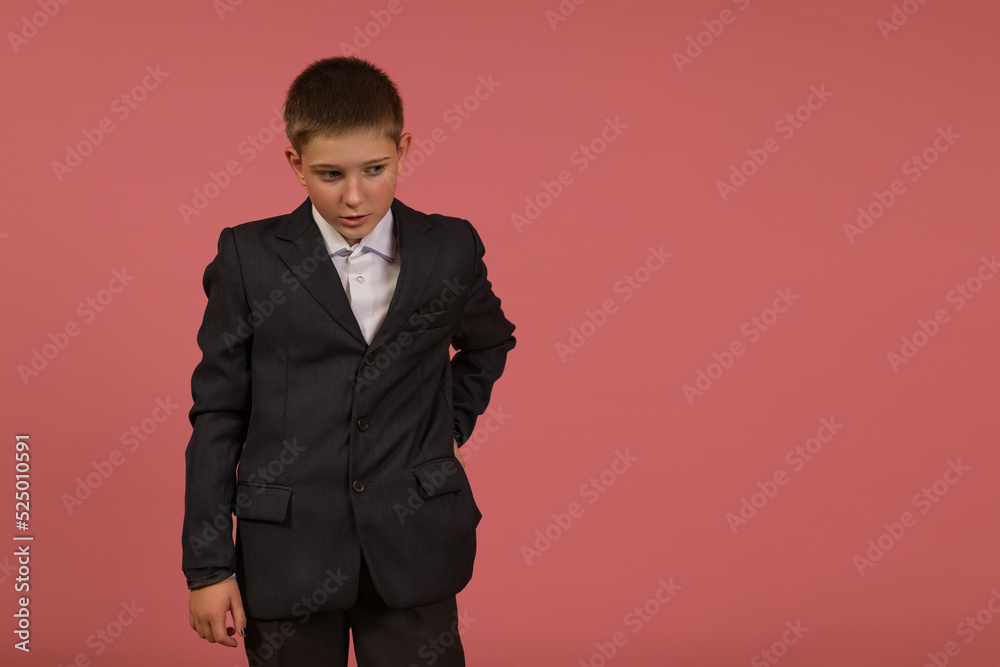 Wall mural schoolboy in black suit on pink background with copy space