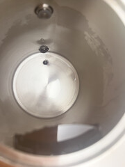 Close-up interior view of clean stainless steel electric kettle with limescale remover with...