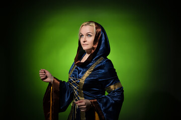 The prophetess in a traditional dress is walking, a portrait on a dark background, hard light.