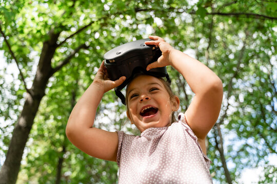 Happy Girl With VR Glasses Standing In Front Of Trees At Park
