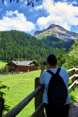 Fototapeta na wymiar A woman taking a photo of tre cime Di Lavaredo at Dolomites