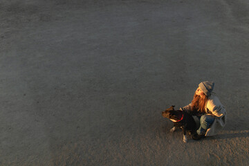 Young woman having fun with her american stanford dog