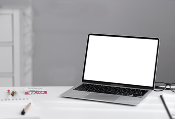 Laptop on white table with white blank screen and copy space. 