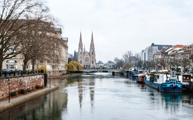 Fototapeta na wymiar Tilt-shift lens used to photograph the city center of Strasbourg with Eglise reformee Saint-Paul and Ill river Pont Royal and large boats vis-a-vis of Escape building