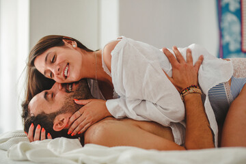 Young beautiful couple having hugging and kissing at home