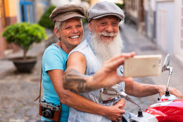 Adult couple making a smartphone selfie on a motorcycle