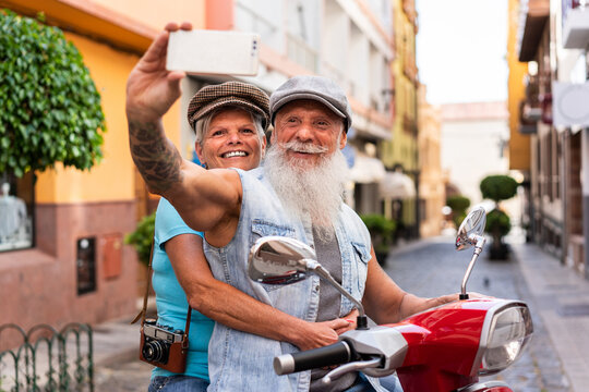 Senior couple making a smartphone selfie on a motorcycle
