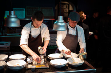Cooks serving meal on restaurant kitchen