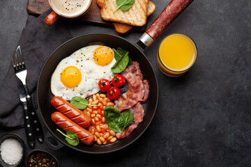 English breakfast with fried eggs, beans, bacon and sausages
