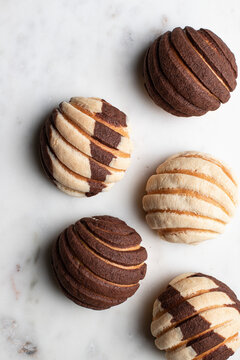 Tasty Mexican conchas on plate in kitchen