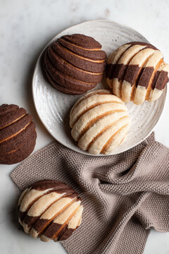 Tasty Mexican conchas on plate in kitchen