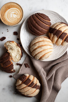 Tasty Mexican conchas on plate in kitchen