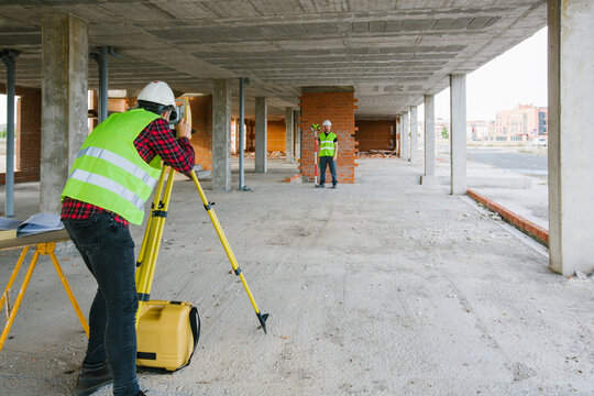 Surveyor engineer working at construction site with measuring eq