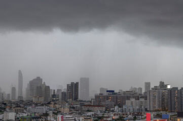 Modern city under dramatic stormy rainy clouds.