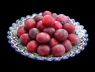 An isolated ripe plum in a beautiful plate