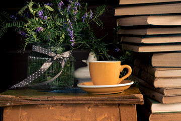 Books, a cup of coffee or tea, a bouquet of flowers on the table. Rest, relax study, education concept. vintage tone