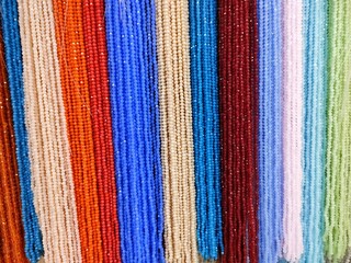 multi-colored beads hang in rows on the wall