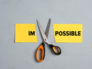 Scissors Cutting off the Word impossible and transforming into possible. Concept of possibility,...