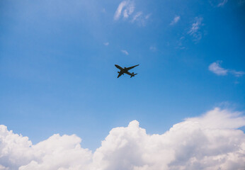 An airplane in the sky. Low angle shot of an aeroplane in a clear blue sky with fluffy clouds.