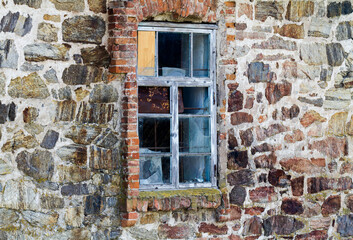 Fototapeta na wymiar Old ruined window in a stone wall