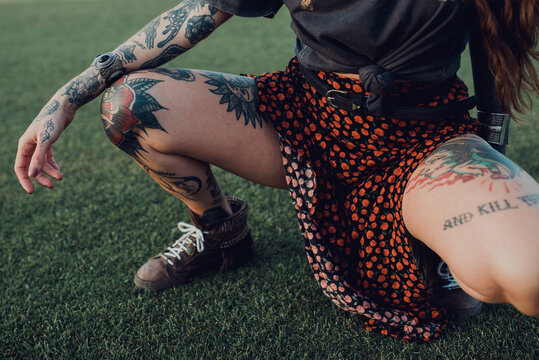 Stylish millennial tattooed woman on lawn