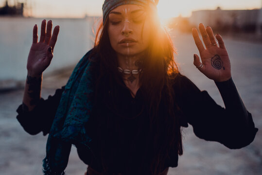 Brunette with ritual white makeup and piercing on street