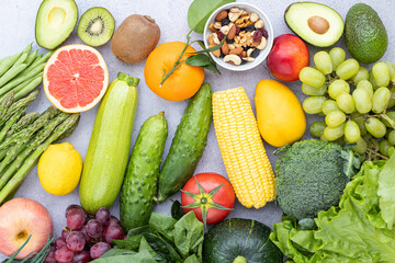 Flat lay of Healthy food with nuts, fresh fruits and vegetables on gray concrete background. Diet and detox lifestyle concept. 