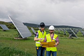 Male engineers discussing solar power plant construction