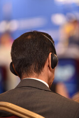Man using translation headphones during a press conference