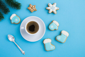 Obraz na płótnie Canvas Christmas composition with coffee cup and gingerbread on the blue background. Top view. Copy space.