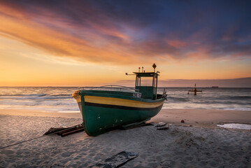Kuter rybacki na plaży w Gdyni Orłowo o wschodzie słońca nad morzem bałtyckim z widokiem na...