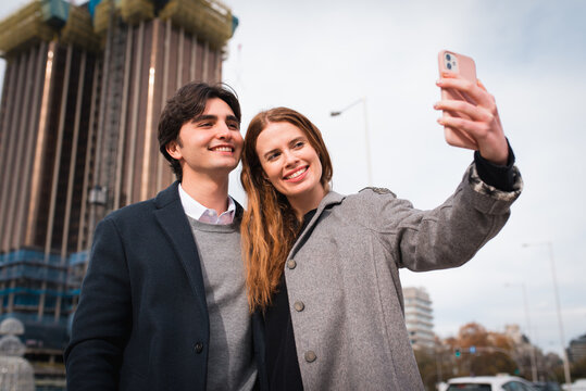 Loving young couple taking selfie on street