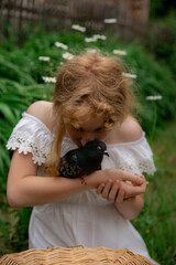 a girl in a white dress holds a dove in her arms 