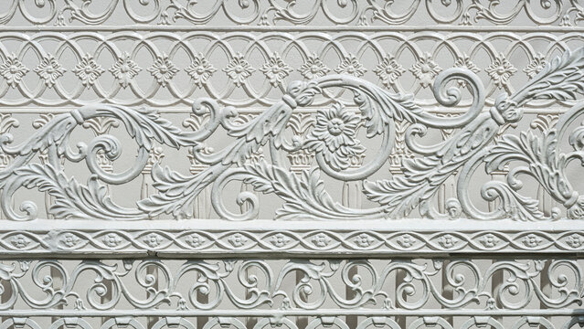 Abstract ornamental and decorative pattern background of vintage white cast iron sliding fence gate in Roman style