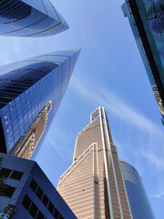 Fototapeta na wymiar Bottom view on skyscrapers and blue sky in Moscow City, Russia. Modern office buildings in the financial district. Abstract background. High quality photo.