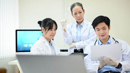 Two Asian scientist working, meeting with an Asian senior female scientist in the laboratory.